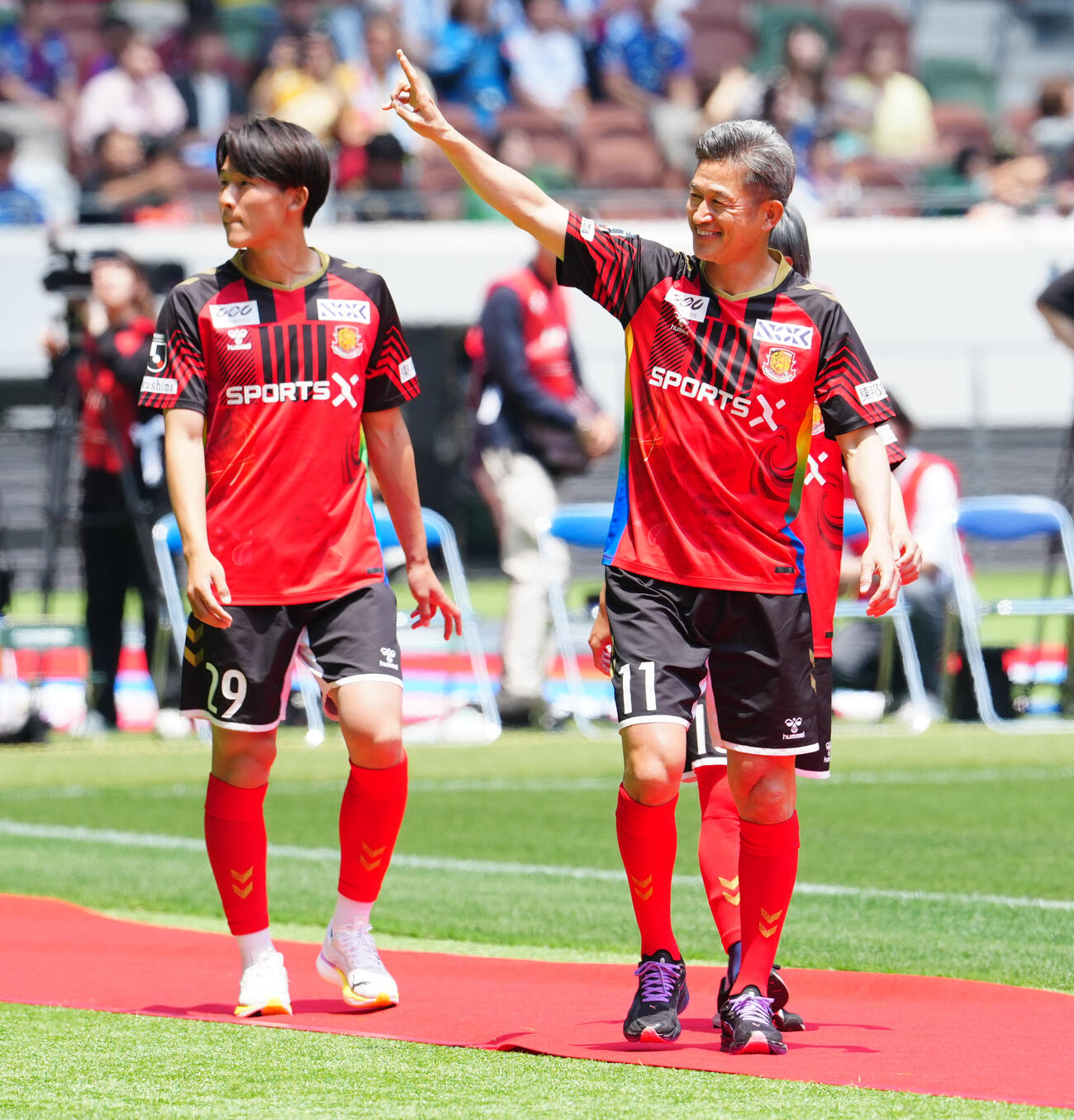 JリーグオールスターDAZNカップ　オープニングセレモニーに登場し、声援に応える福島カズ（三浦知良）（右）（撮影・鈴木みどり）