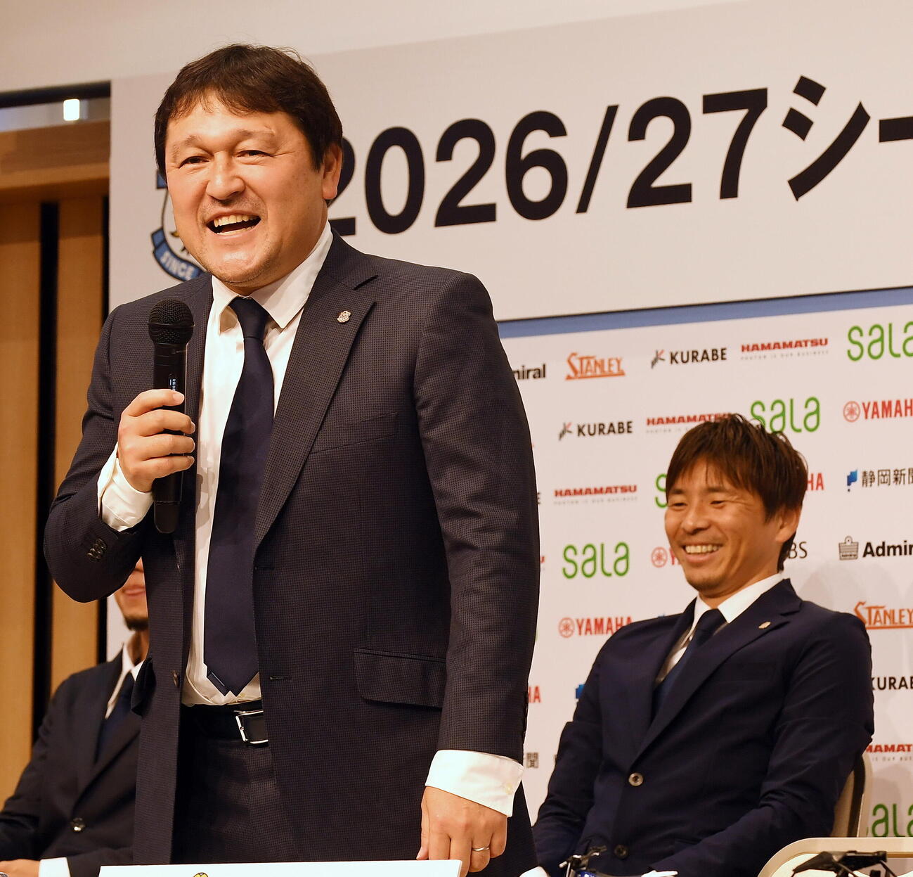 会見で語る磐田秋葉監督。後方は笑顔を見せる乾