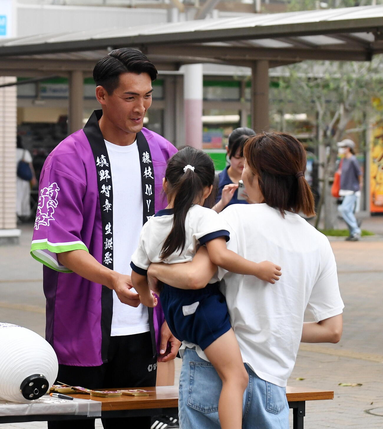 会話をしながらステッカーを手渡す藤枝槙野監督