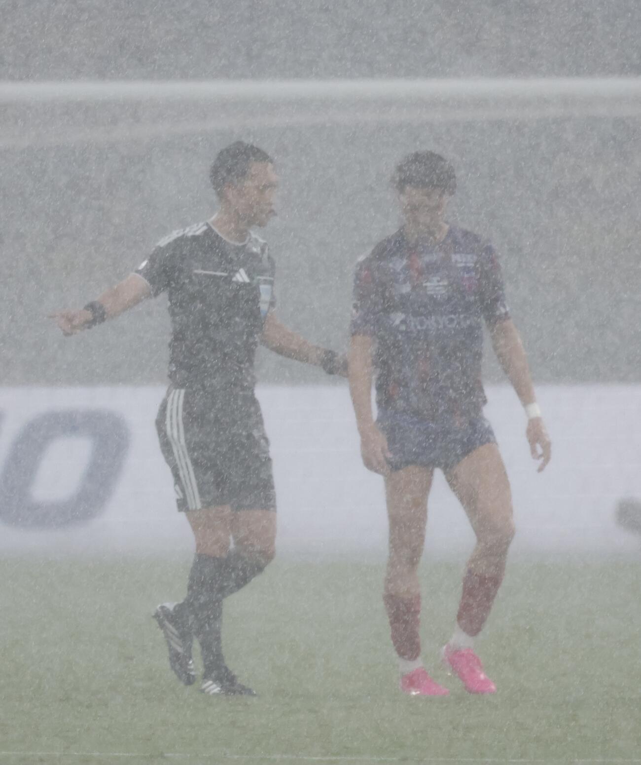 東京対ドルトムント　前半、雷雨中断を指示する高崎航地主審（左）（撮影・山本朝陽）
