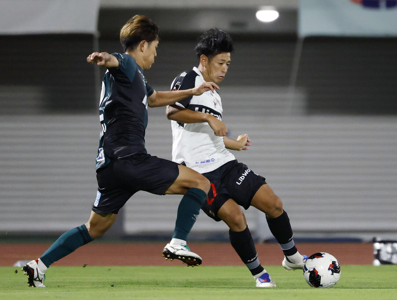 サッカーJ3の相模原戦で競り合う熊本の松田詠太郎（右）＝8日、相模原ギオンスタジアム