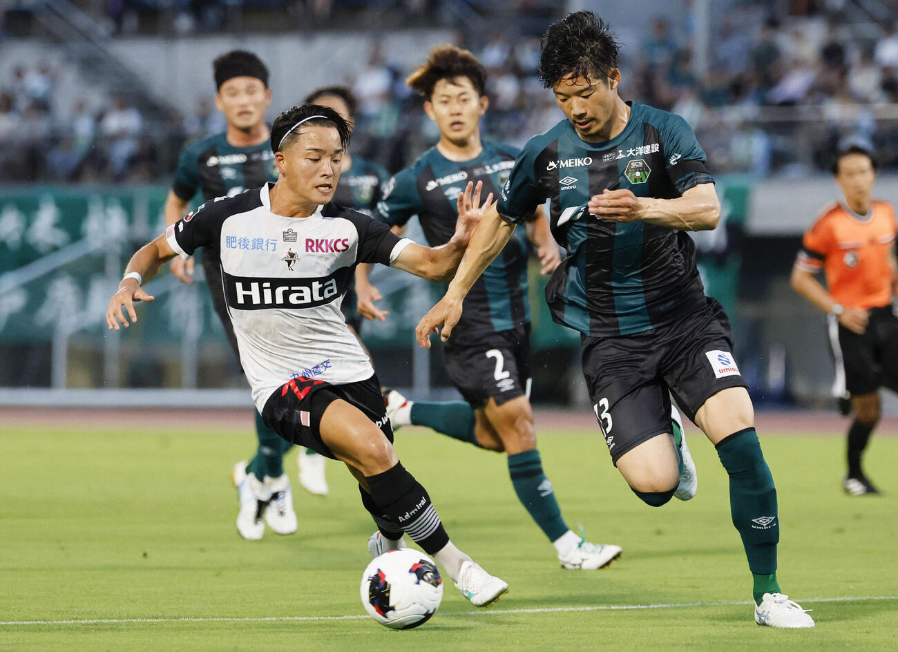 サッカーJ3の相模原戦で競り合う熊本の三品直哉（手前左）＝8日、相模原ギオンスタジアム