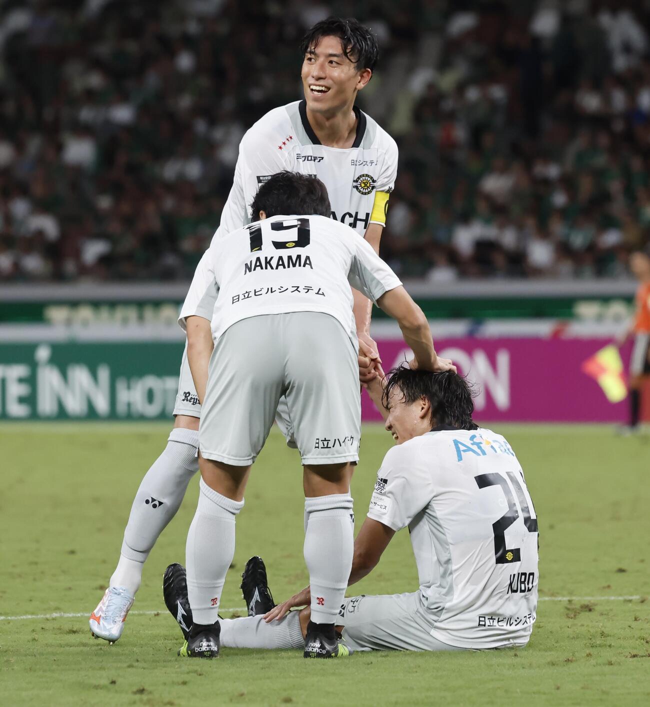 東京V対柏　後半、ゴールを決めた際に足を攣り、座り込む柏久保藤次郎（右）とゴールを祝福をする柏イレブン（撮影・山本朝陽）