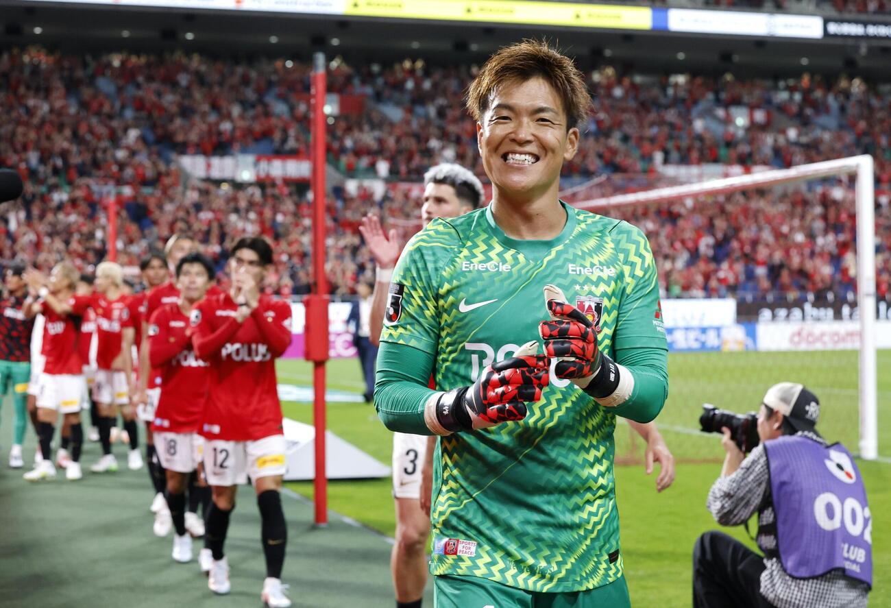 横浜Mに競り勝ち、笑顔でサポーターにあいさつする浦和・GK西川周（手前）＝埼玉スタジアム（共同）