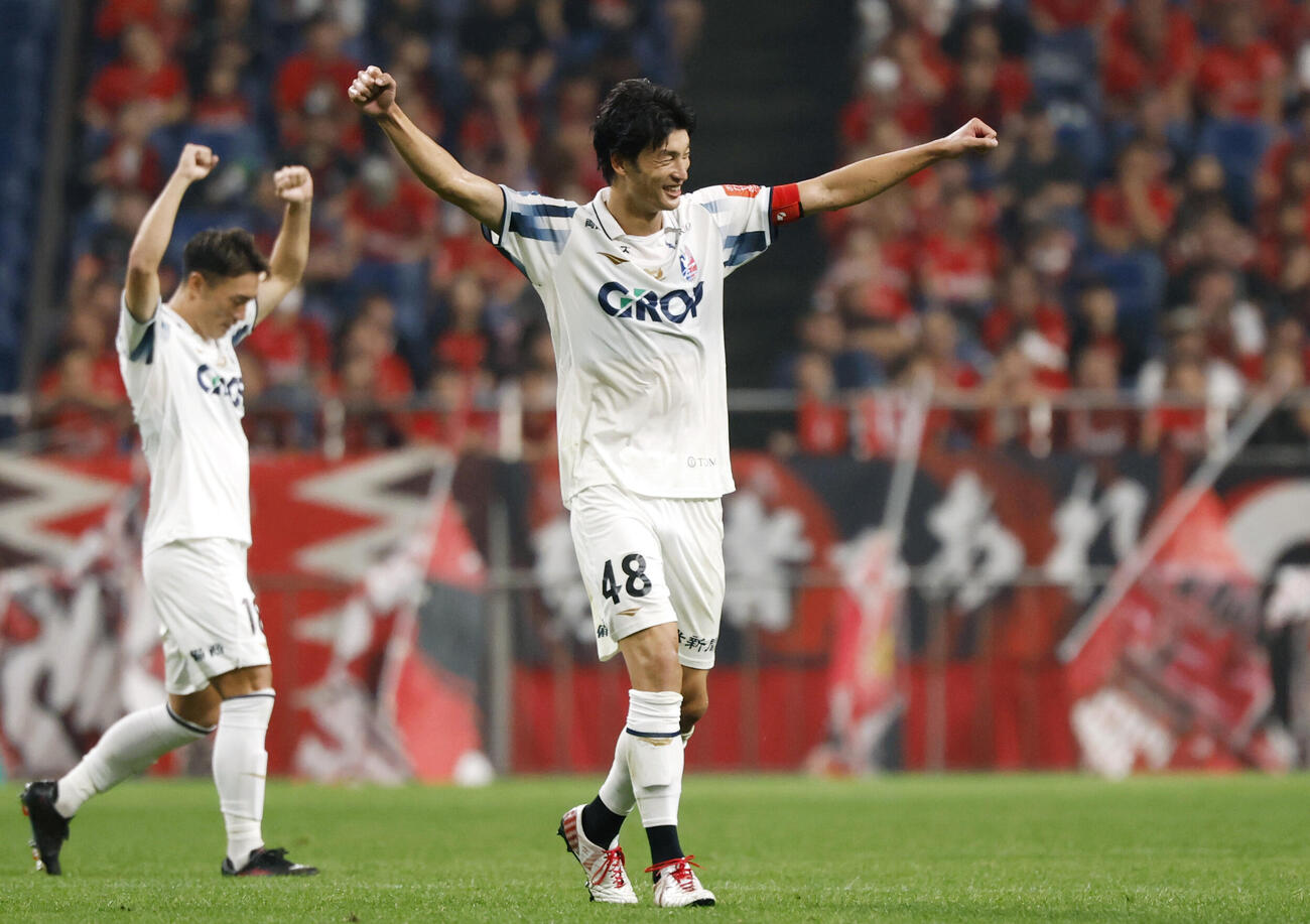 浦和に競り勝ち、ガッツポーズで喜ぶ岡山・立田（右）＝埼玉スタジアム（共同）