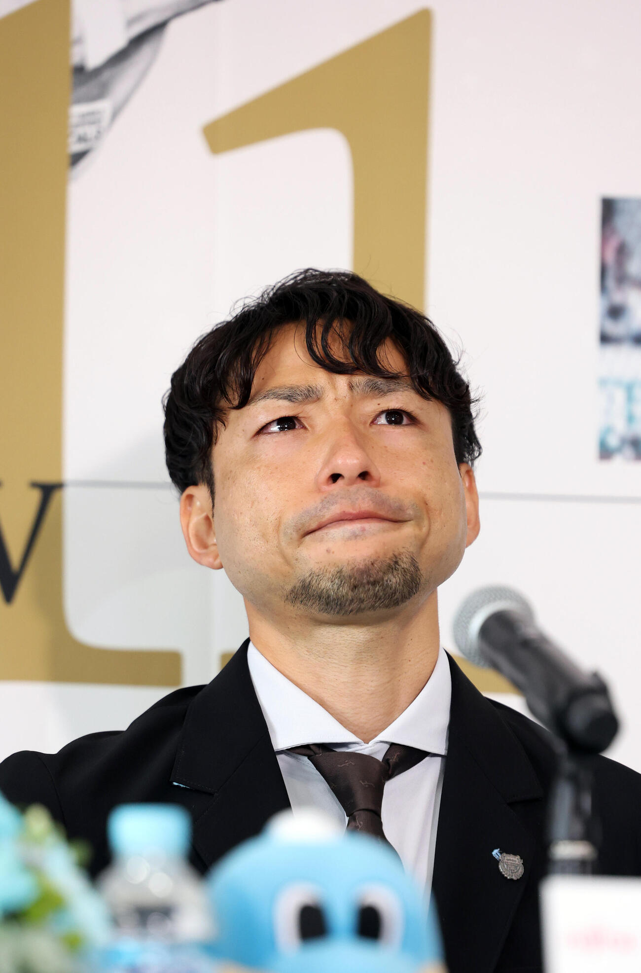 背番号11のボードを背に涙をこらえて会見する川﨑F小林悠（撮影・浅見桂子）