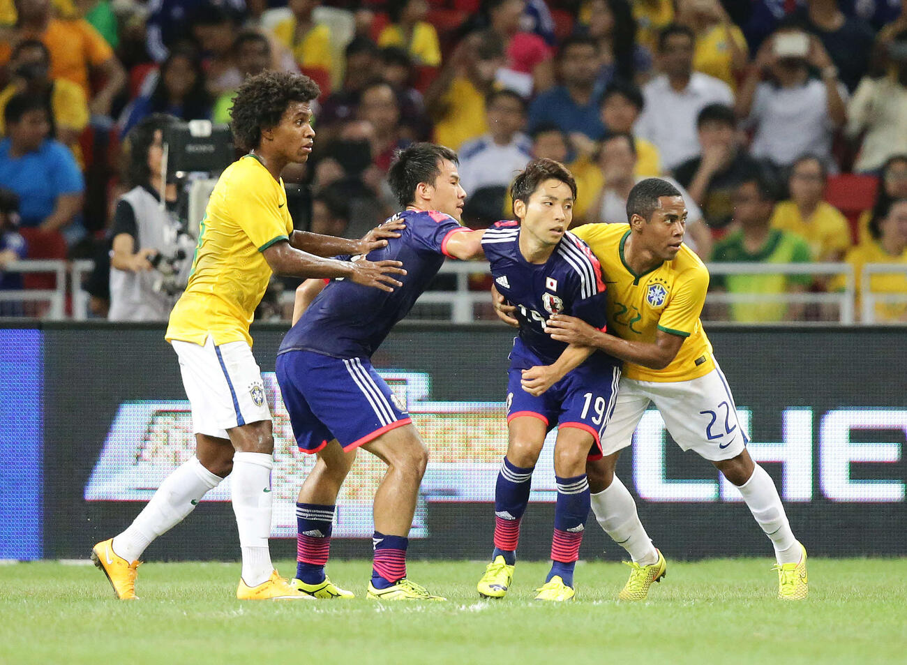 2014年10月、国際親善試合　日本対ブラジル　前半、ゴール前でポジションを争う、左からビリアン、岡崎慎司、小林悠、エリアス