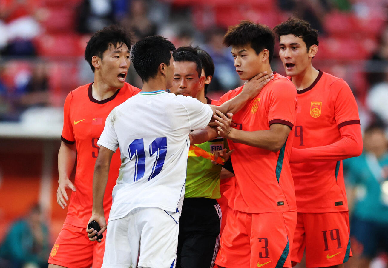 アジア大会サッカー3位決定戦　PK戦の最中、小競り合いするウズベキスタンのアシルベク・ジュマエフと中国の劉浩凡（ロイター）