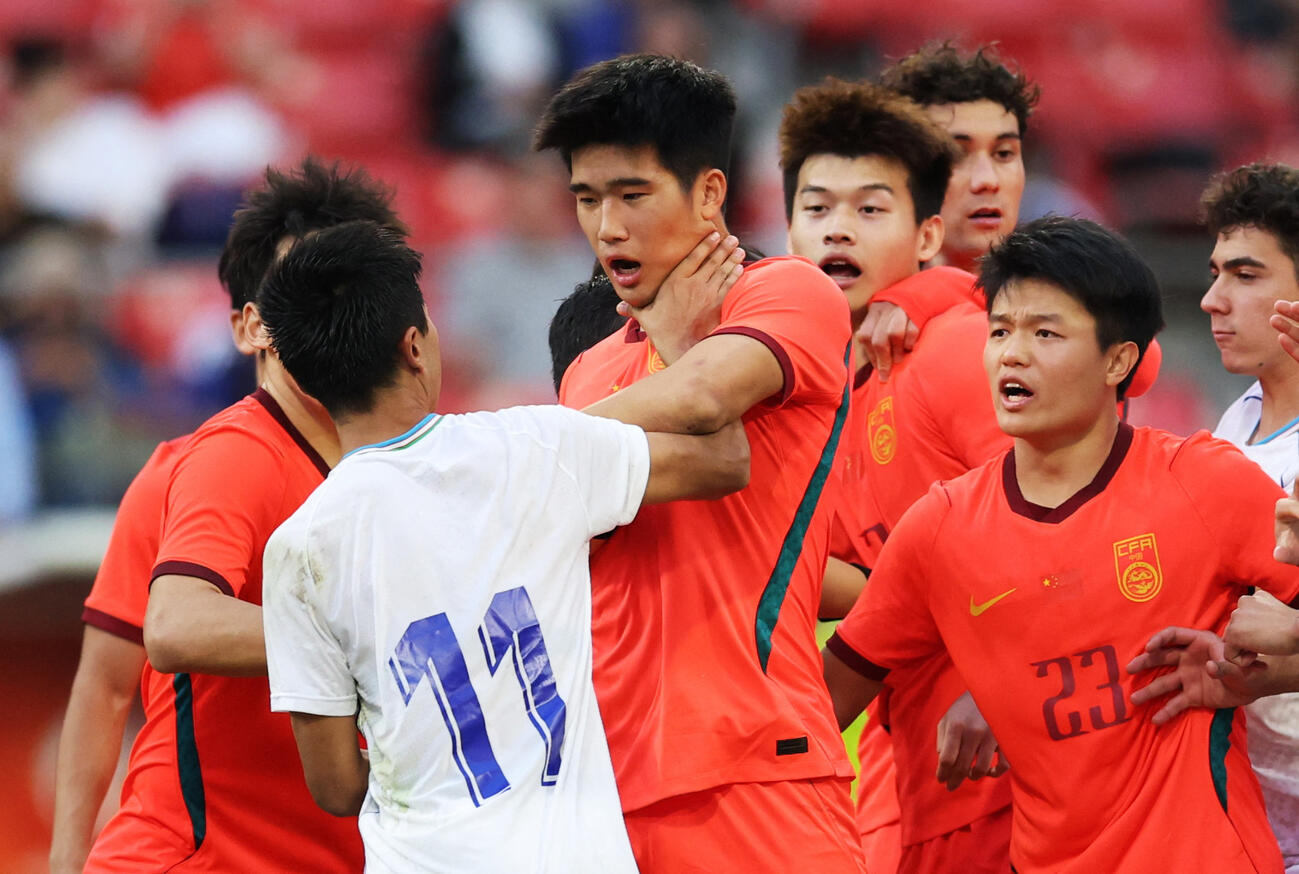 アジア大会サッカー3位決定戦　PK戦の最中、小競り合いするウズベキスタンのアシルベク・ジュマエフと中国のシャオ・ペン（ロイター）