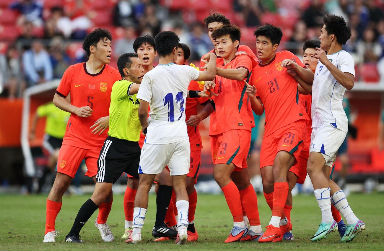 アジア大会サッカー3位決定戦　PK戦の最中、小競り合いするウズベキスタンのアシルベク・ジュマエフが中国の劉浩凡、肖鵬（ロイター）