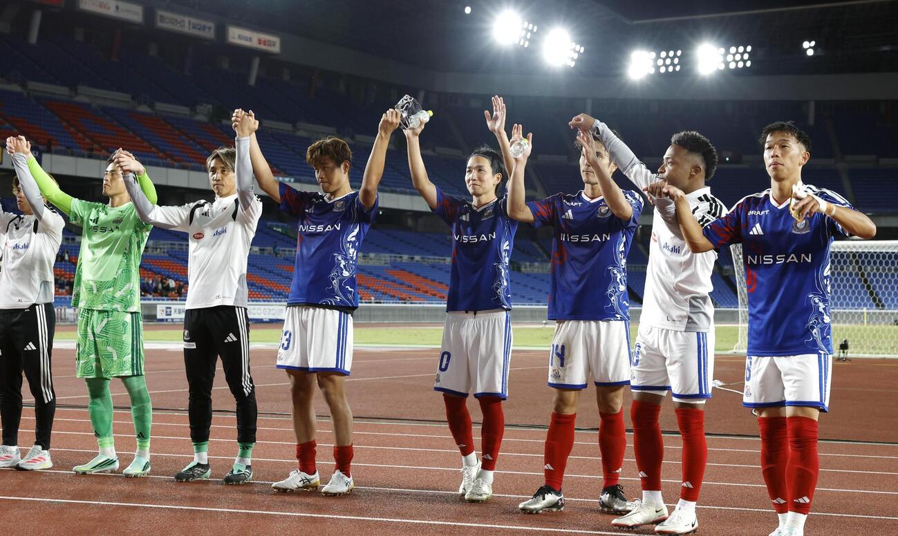 京産大に勝利し、サポーターと喜びを分かち合う横浜Mの選手たち＝日産スタジアム（共同）