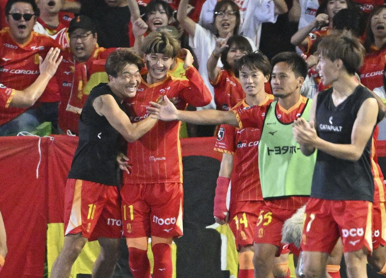 川崎－名古屋　後半、決勝ゴールを決めた山岸を祝福する名古屋・永井（左端）＝U等々力（共同）