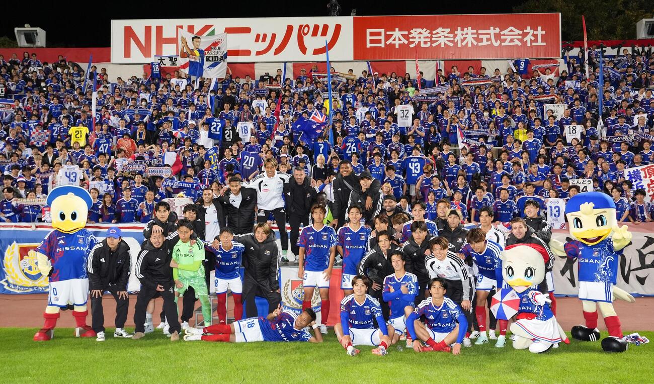 広島に競り勝ち、サポーターと写真に納まる横浜の選手たち（共同）