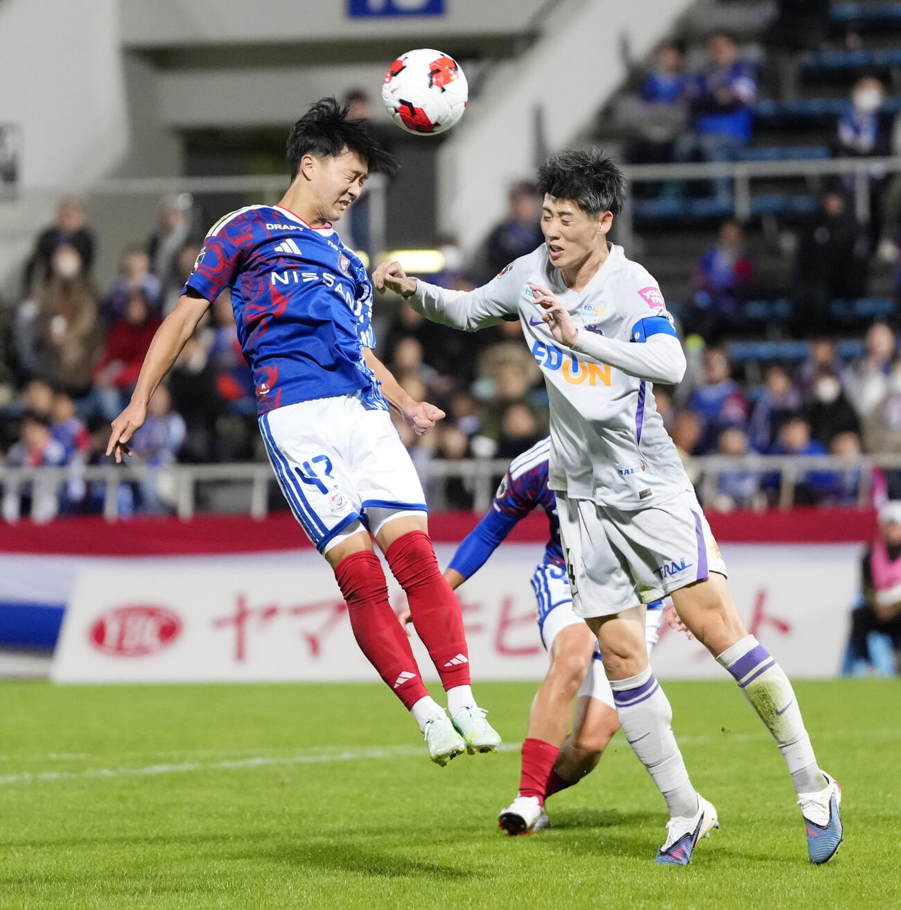 横浜－広島　前半、競り合う横浜三井寺（左）と広島荒木（共同）