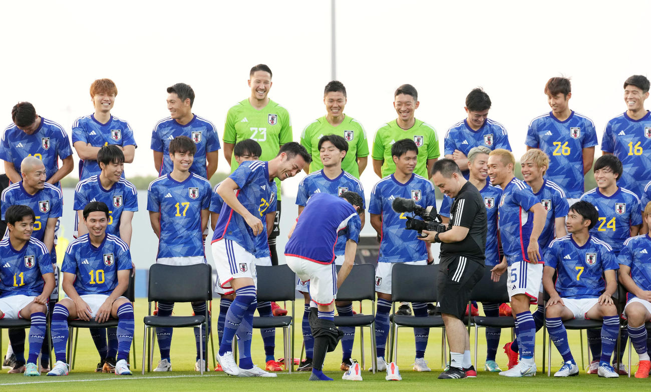 集合写真でユニホームに着替える日本代表専属シェフの西芳照さん（中央右）を笑顔で見つめる吉田（同左）ら（撮影・横山健太）