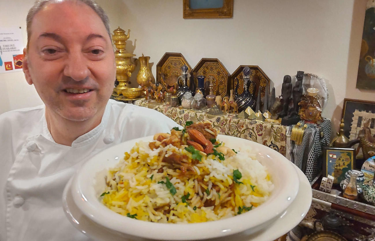 横浜市のアラビア料理「アル・アイン」のオーナーシェフのジアード・カラムさん。手前はカタールの家庭料理の代表格、アラビア風ピラフ「カプサ」（撮影・寺沢卓）