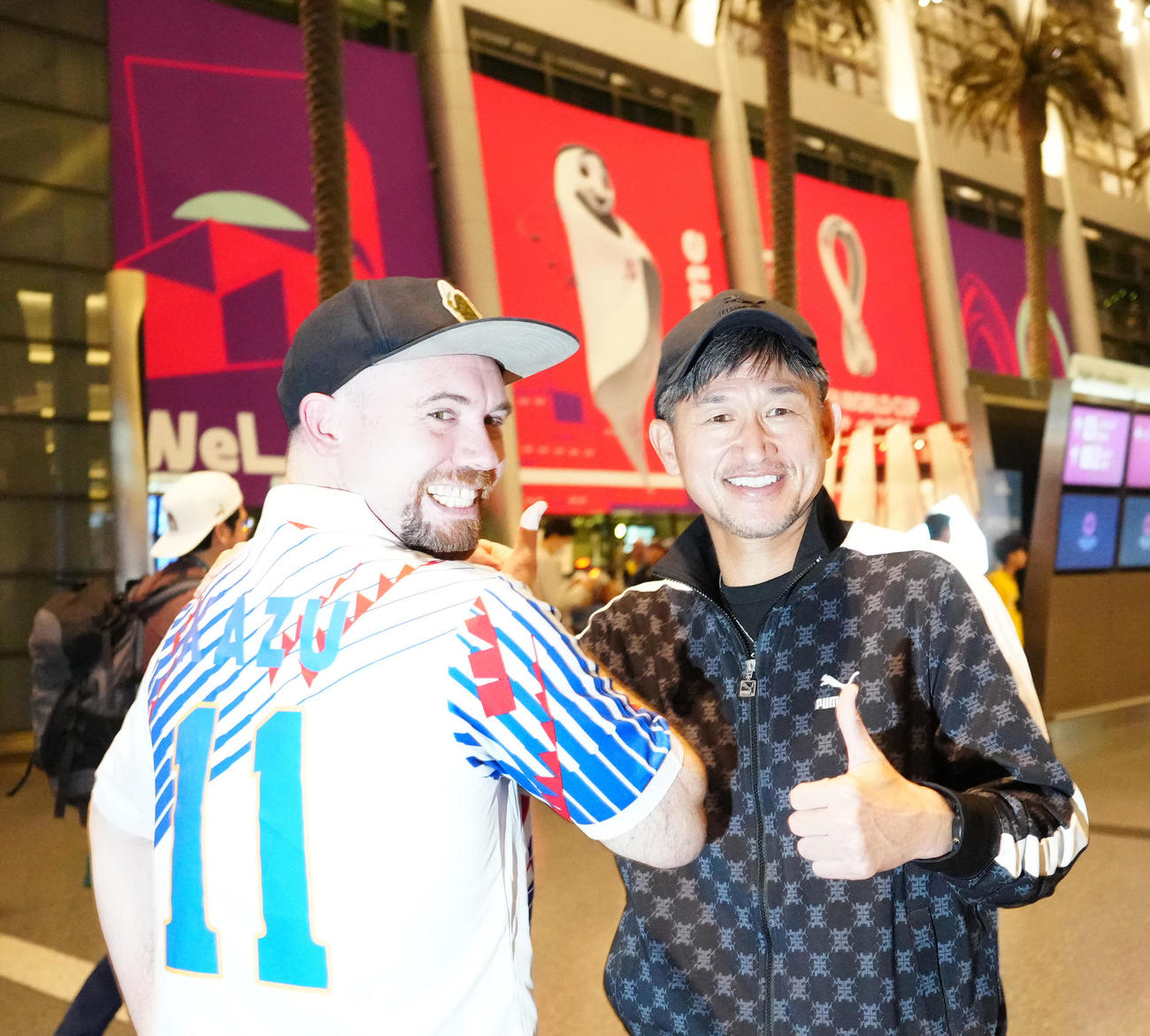 カタール・ドーハ入りし、ユニホームを着たファンのアンドリューさん（左）と写真に納まるカズ（撮影・江口和貴）