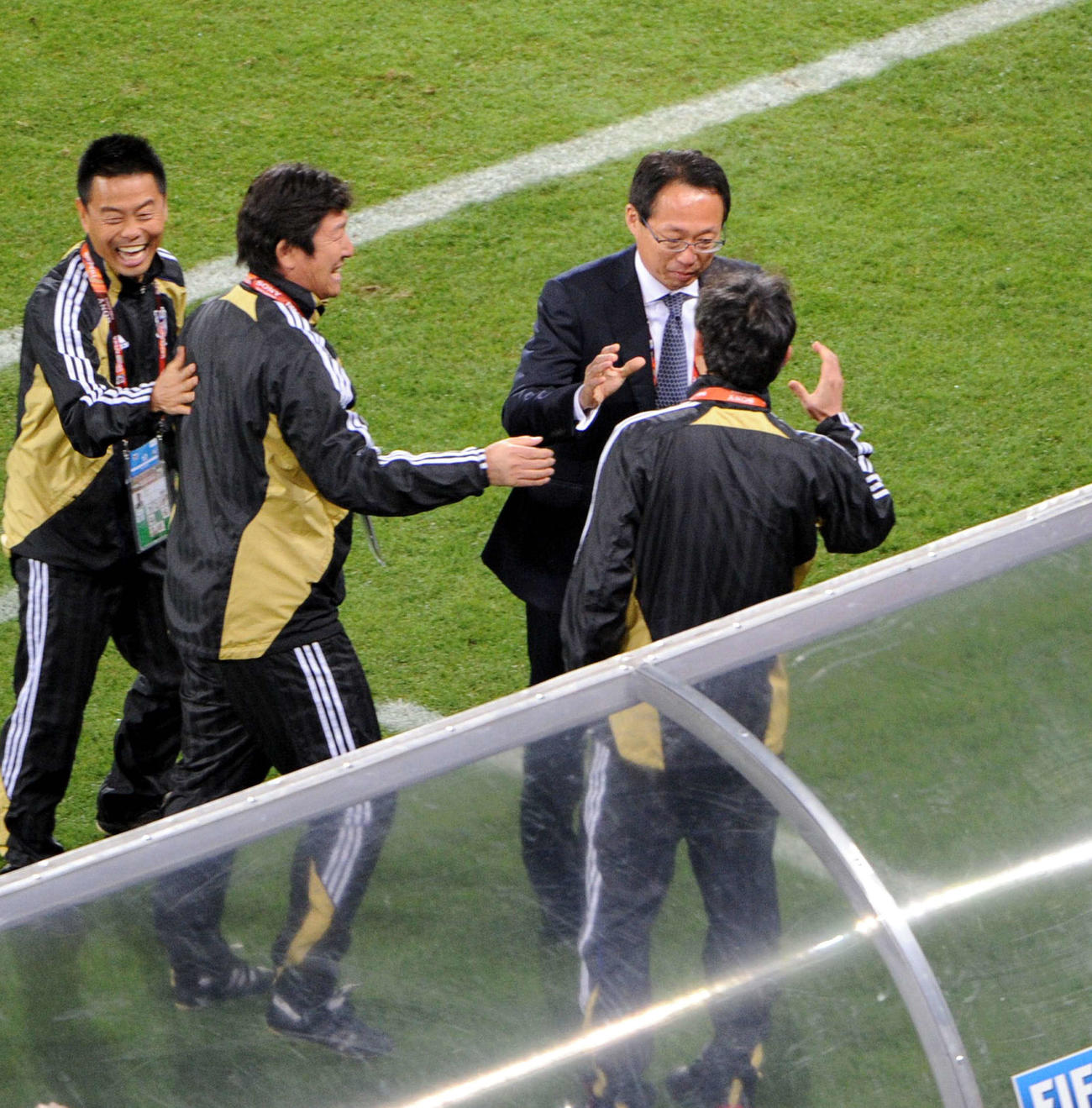 10年6月、W杯南アフリカ大会1次リーグでカメルーンを下しスタッフと握手をかわす岡田監督（中央）