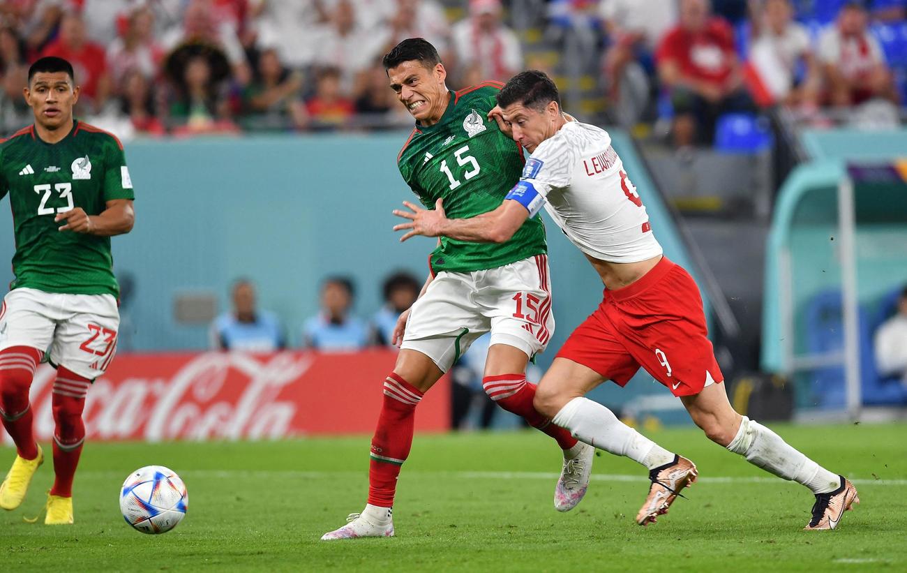 後半・メキシコ・モレノ（中）に引っ張られるポーランド・レバンドフスキ（右）。VAR判定の末PKが与えられた（ロイター）