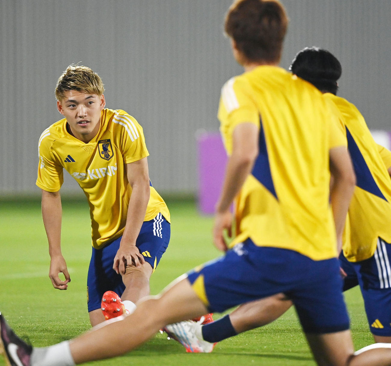 ストレッチをする堂安（左）（撮影・横山健太）