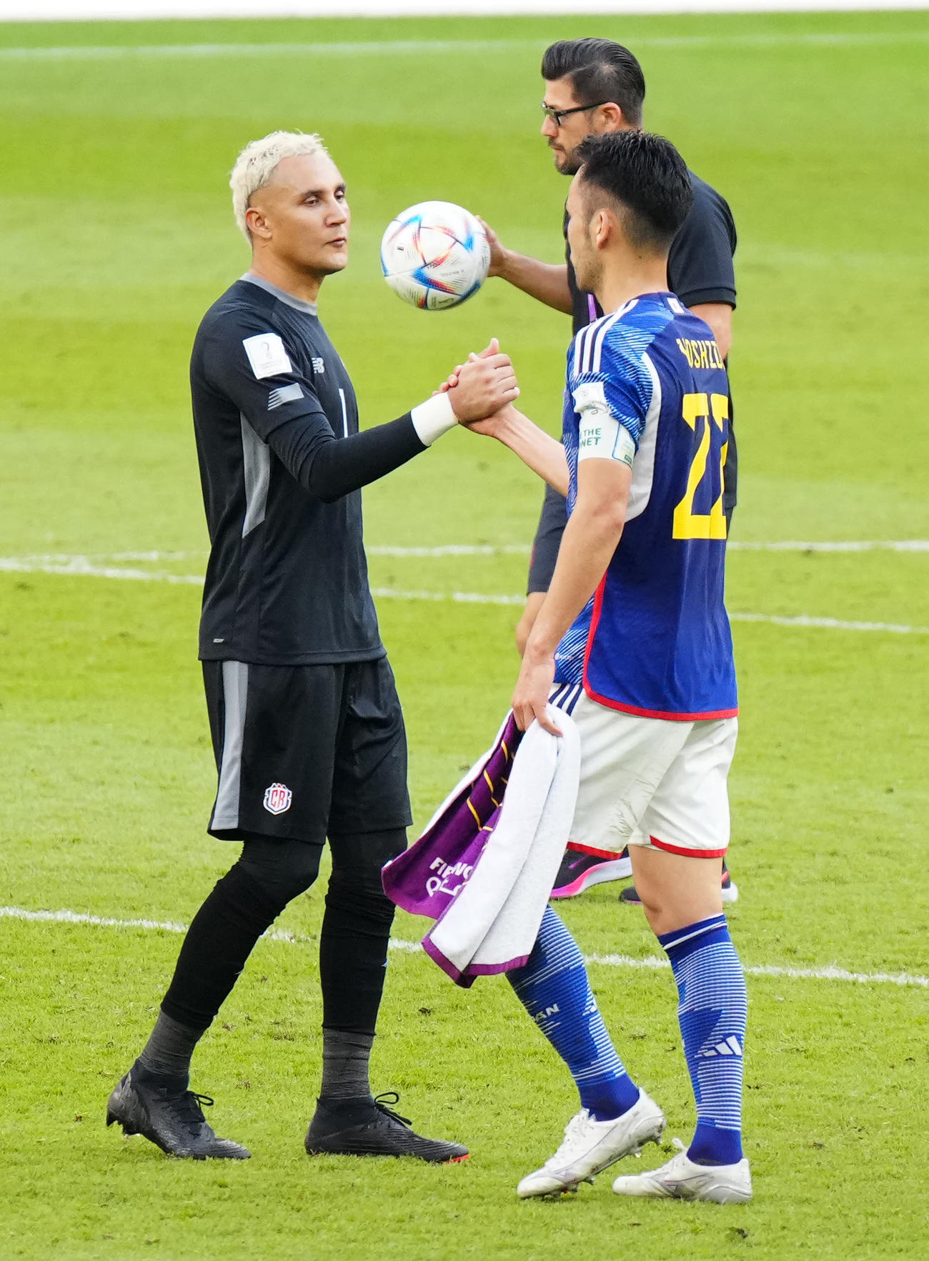 握手を交わす吉田（右）とGKナバス（2022年11月27日撮影）