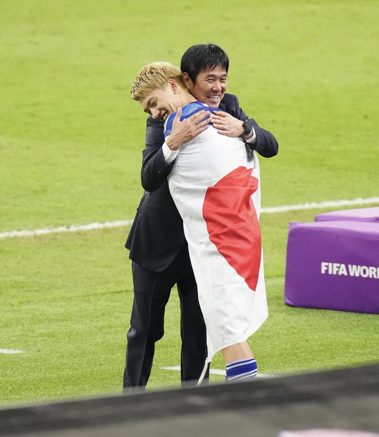 日本対スペイン試合後、日の丸をまとった堂安を優しく抱きしめる森保一監督（撮影・江口和貴）