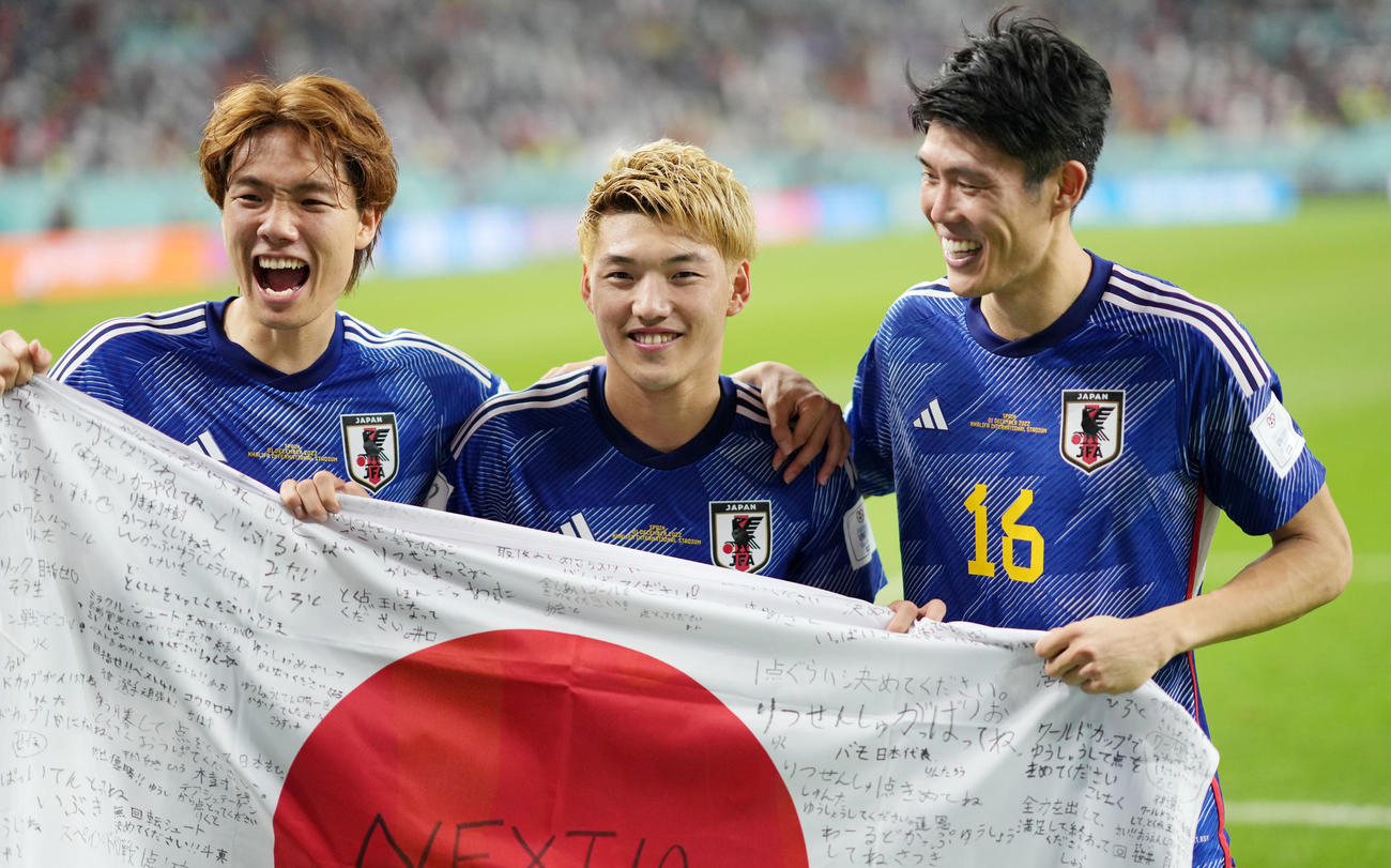 日本対スペイン　決勝トーナメント進出を決め、日の丸を手に笑顔を見せる、左から板倉、堂安、冨安（撮影・横山健太）