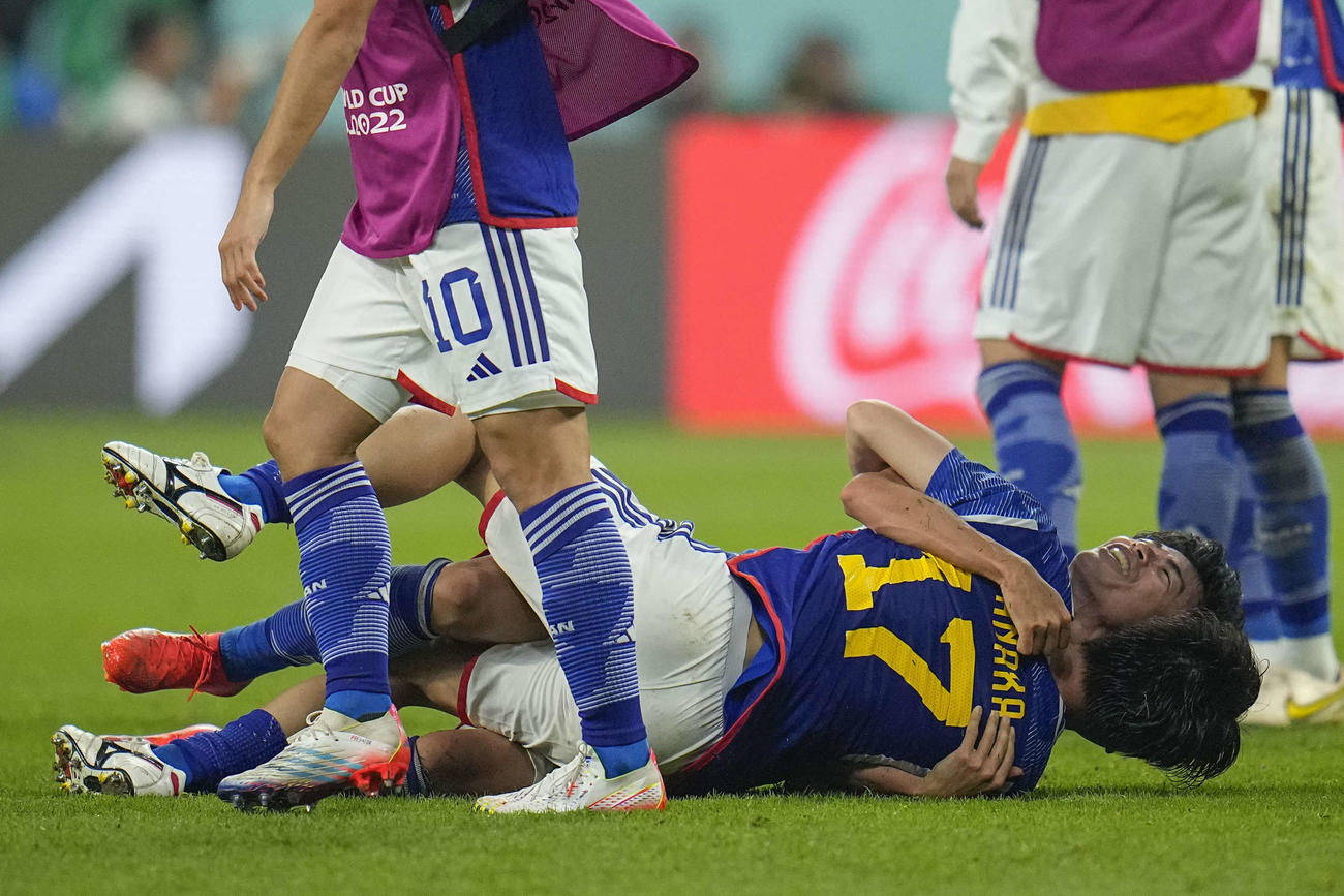 スペインに勝利しピッチで抱き合う田中（手前）と三笘（AP）