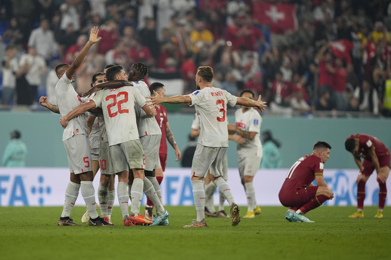 セルビア－スイス戦、1次リーグ突破を決めて喜ぶスイスの選手たち。後方は敗退が決まりうなだれるセルビアの選手たち（AP）