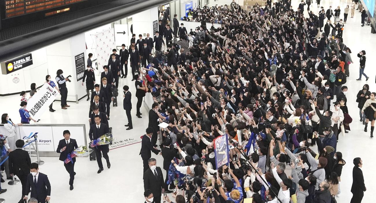 帰国した森保一監督（左下）ら日本代表と出迎える大勢の人たち（共同）