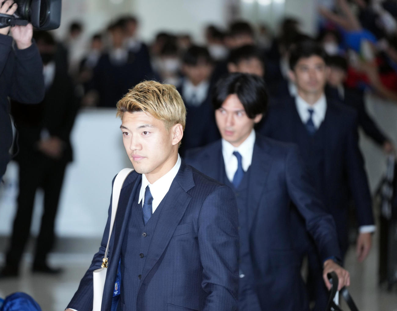 多くのサポーターが迎える中、カタールから帰国する堂安（手前）ら日本代表の選手たち（撮影・狩俣裕三）
