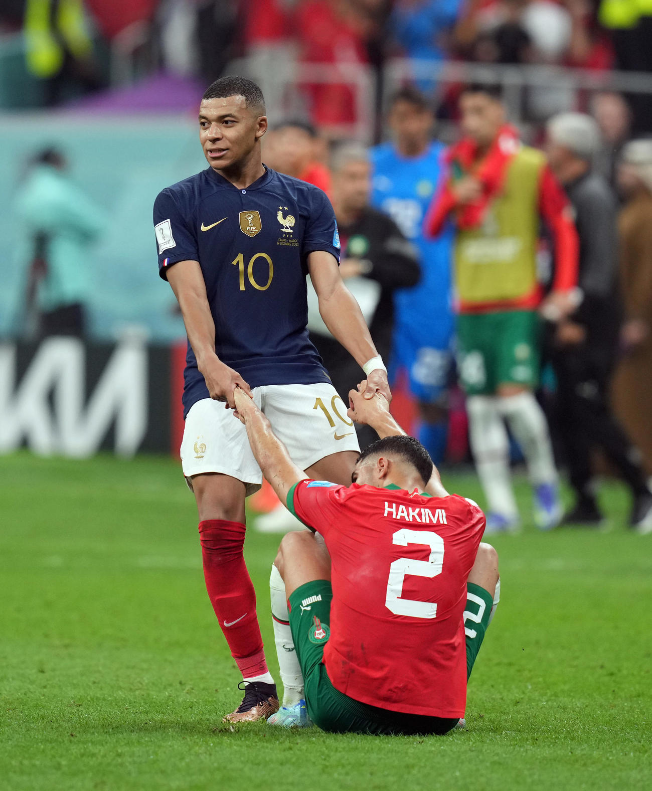 フランス対モロッコ　試合後、ピッチに倒れこむモロッコ・ハキミ（右）に手を差し伸べるエムバペ（撮影・パオロ　ヌッチ）