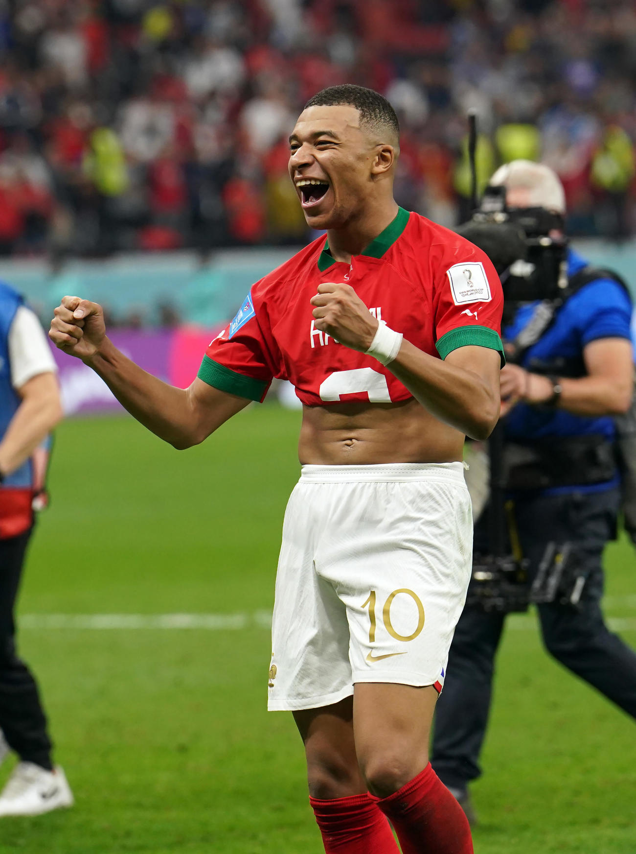 試合後、モロッコ・ハキミと交換した赤いユニホームを着てガッツポーズするエムバペ（撮影・パオロ・ヌッチ）