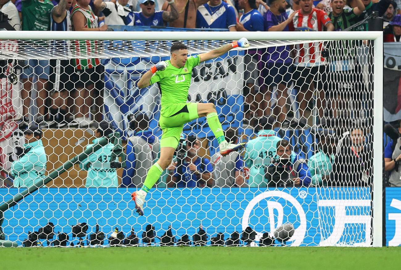 PK戦、フランス2人目のコマンのキックを止めて、ジャンプして喜ぶアルゼンチンGKエミラノ・マルティネス（ロイター）