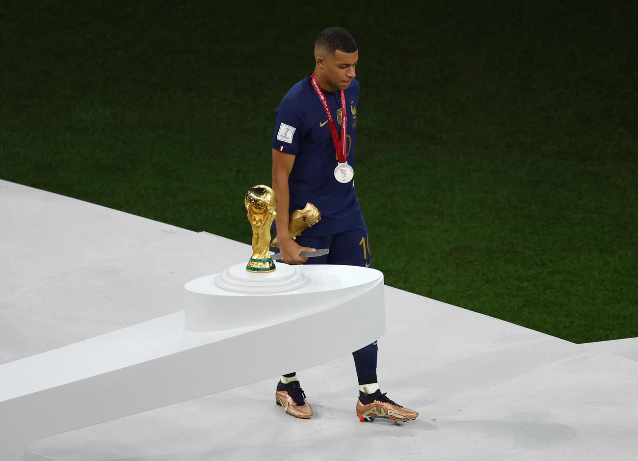 得点王に輝くも無念の表情でW杯トロフィーの横を通り過ぎるフランス・エムバペ（ロイター）