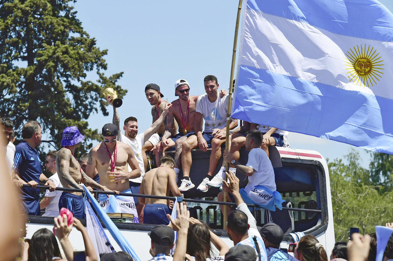 20日、アルゼンチン・ブエノスアイレスの凱旋（がいせん）パレードで、優勝トロフィーを掲げるメッシ選手ら（AP＝共同）