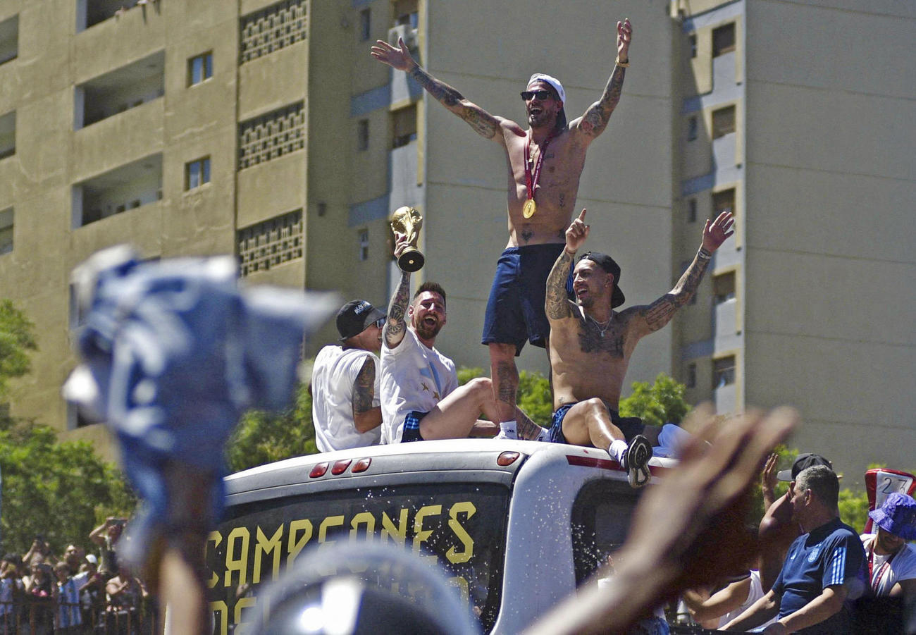 20日、アルゼンチン・ブエノスアイレスの凱旋（がいせん）パレードで、優勝トロフィーを掲げるメッシ選手ら（ロイター＝共同）