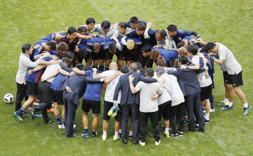 試合前の練習で円陣を組む日本イレブン（共同）