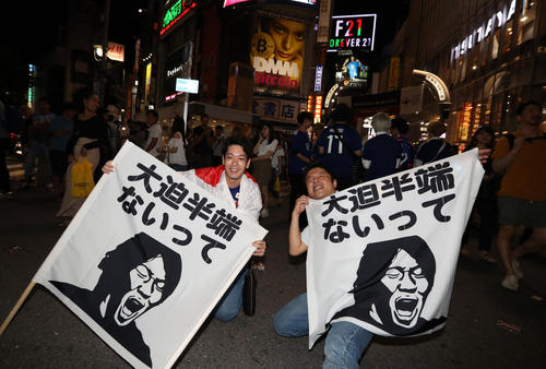 渋谷のスクランブル交差点で「大迫半端ないって」フラッグを広げるサポーター（撮影・狩俣裕三）