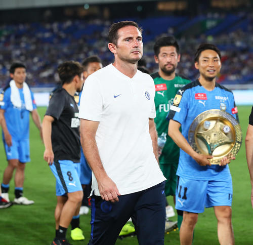 川崎F対チェルシー　川崎Fに敗れ喜ぶFW小林（右端）らの前を渋い表情で引き揚げるチェルシーのランパード監督（撮影・足立雅史）
