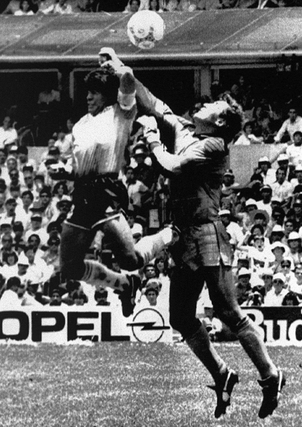 1986年W杯メキシコ大会準々決勝のイングランド戦で、GKシルトン（右）と競り合いゴールを決めるアルゼンチンのマラドーナさん。ハンドではないかと議論を呼んだ「神の手ゴール」（ロイター＝共同）