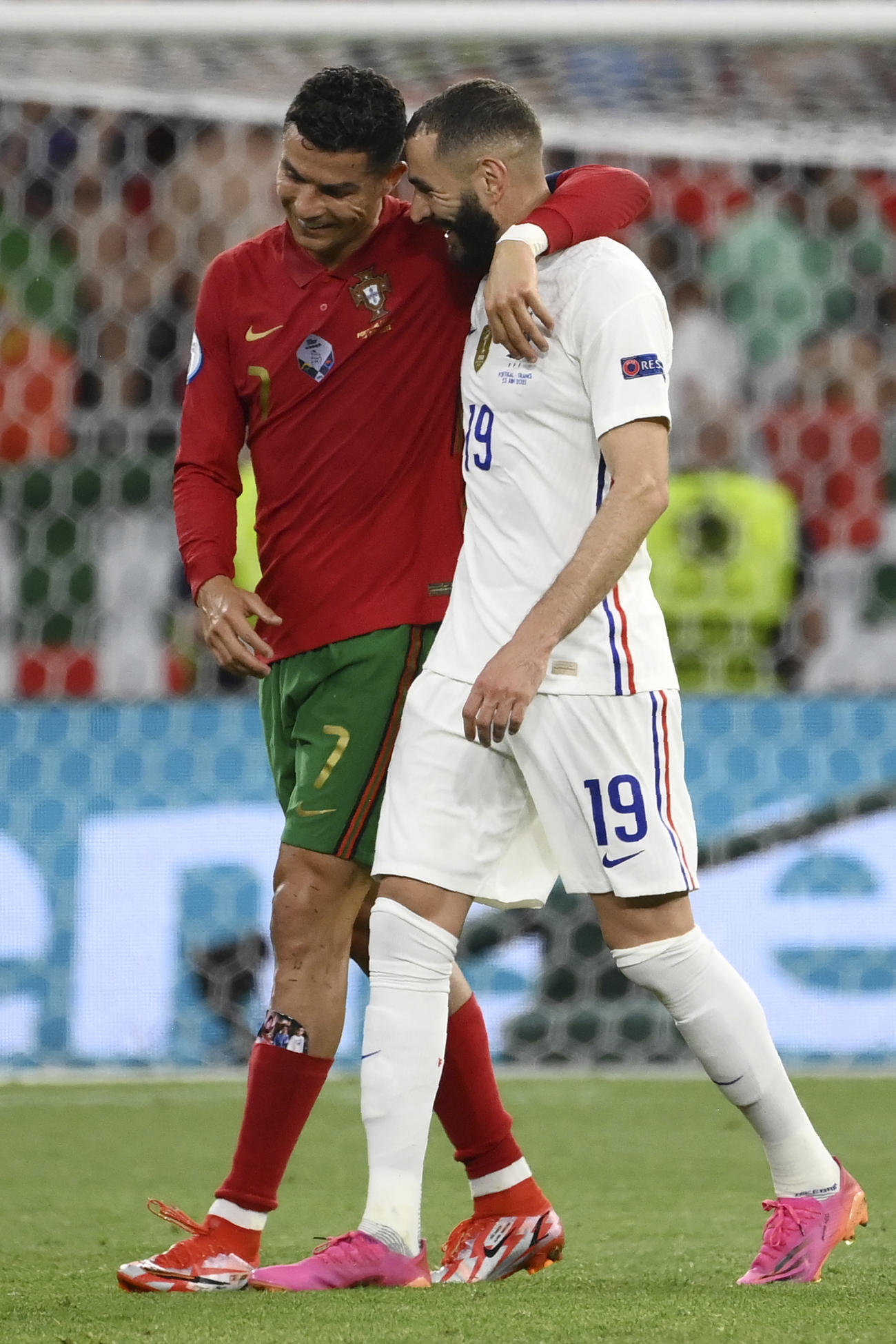 ハーフタイムにポルトガルFWロナウド（左）と肩を組んでロッカールームへ引き揚げるフランスFWベンゼマ（AP）