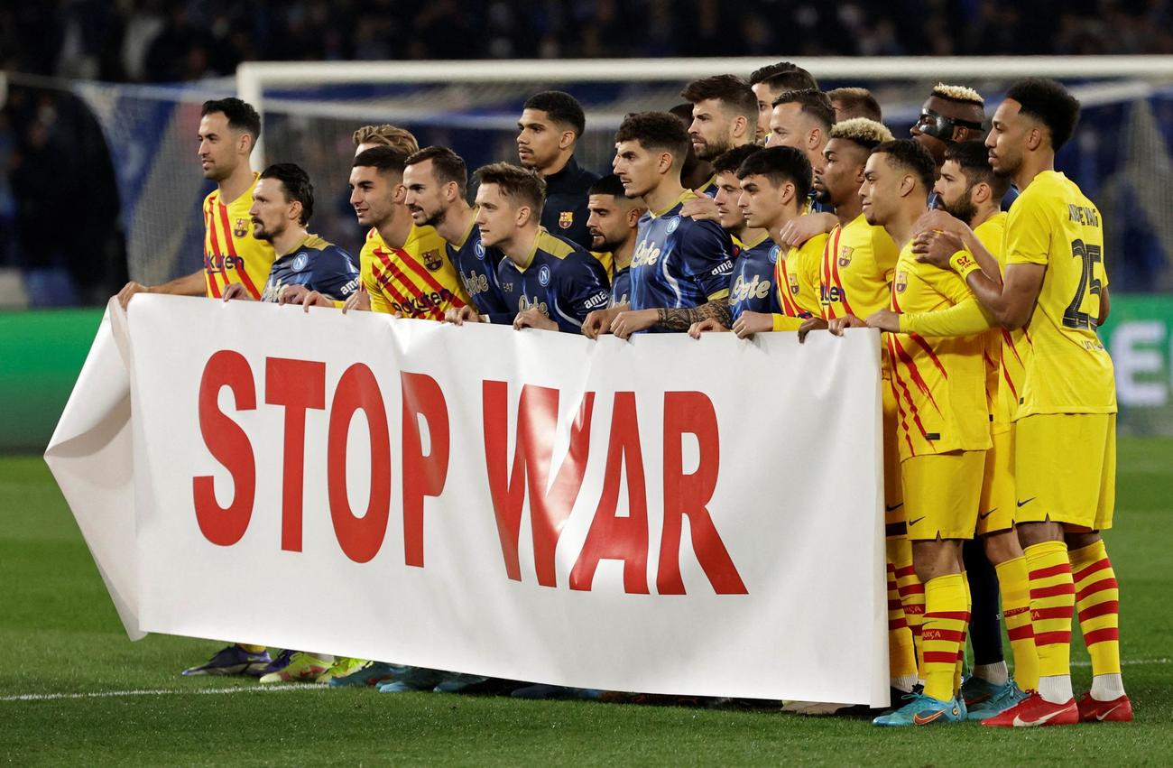 バルセロナ、ナポリ両軍の選手がピッチ上に集合。「STOP WAR（戦争をやめて）」という横断幕を掲げた（ロイター）