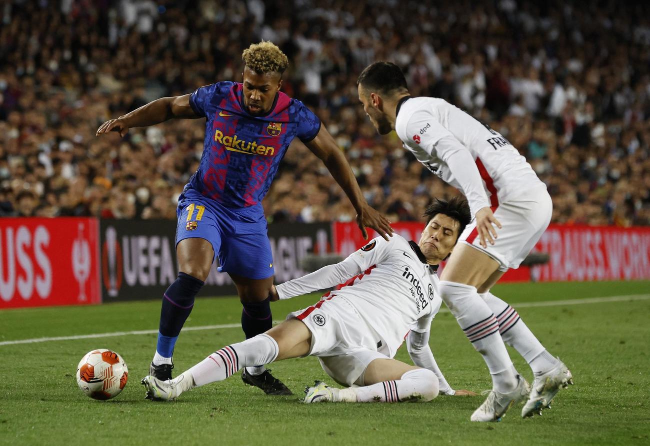 欧州リーグ準々決勝　バルセロナ戦、スライディングしてボールに足を伸ばすフランクフルト鎌田大地（中央下）（ロイター）