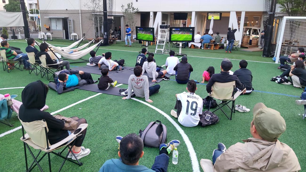 サッカースクールのピッチ上で思い思いの観戦スタイルで約100人が欧州CL決勝に声援を送った（撮影・寺沢卓）