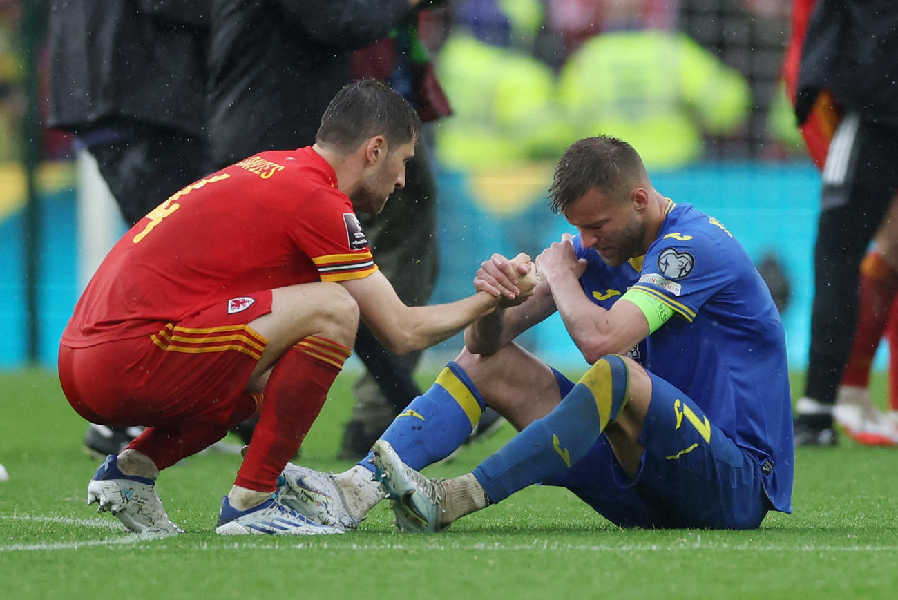 試合後、ピッチに座り込むウクライナFWヤルモレンコ（右）に声を掛けるウェールズのベン・デイビス（ロイター）