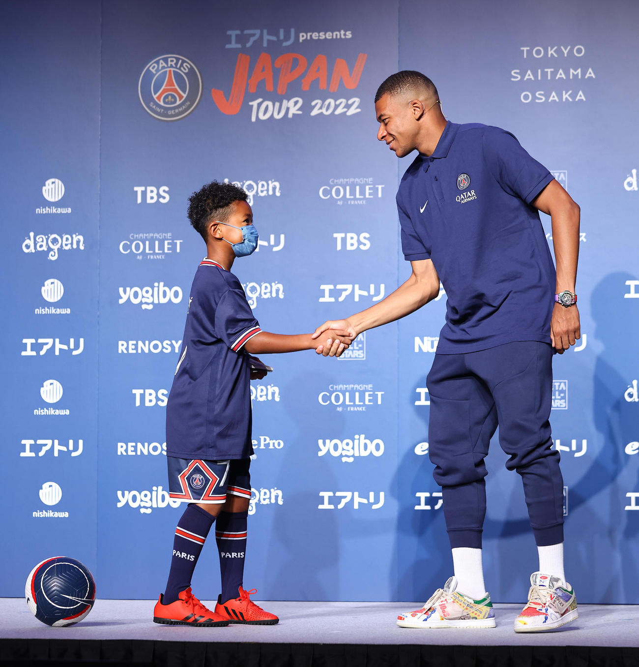 「パリサンジェルマン　ジャパンツアー2022」来日会見で当選した子どもと握手を交わすパリサンジェルマンのエムバペ（右）（撮影・垰建太）