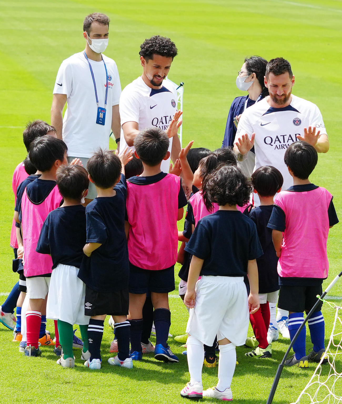 サッカークリニックで参加した子どもたちとタッチを交わすパリ・サンジェルマンのメッシ（後方右端）とマルキーニョス（同中央左）（撮影・江口和貴）