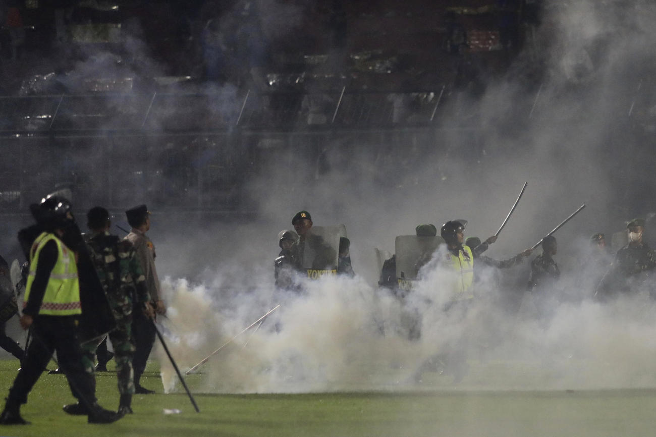 サポーターの乱闘が発生し、催涙弾の白い煙が立ちこめるカンジュルハンスタジアムで（AP）