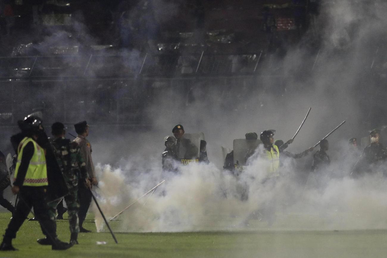 インドネシア東ジャワ州のサッカー場で、催涙ガスを使う警察官＝1日（AP＝共同）